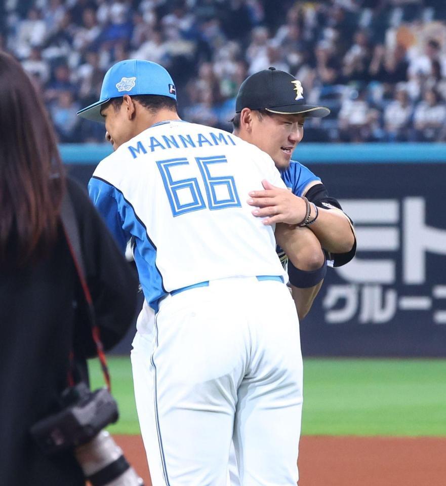 ファーストピッチセレモニーに登場し、万波（左）と抱き合う中田翔氏（撮影・中島達哉）