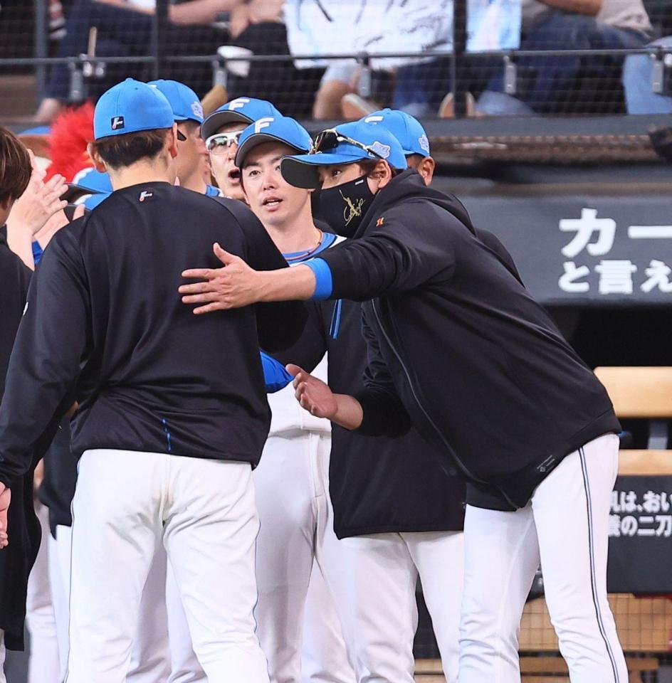 加藤らナインを迎える新庄監督（右）＝２４日