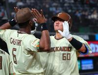 ５回、左越えに勝ち越しソロを放ちナインに迎えられる吉田（撮影・金田祐二）