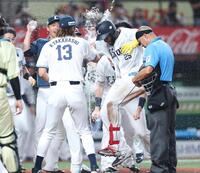 ９回、サヨナラ本塁打を放ちナインに迎えられるカナリオ（撮影・金田祐二）
