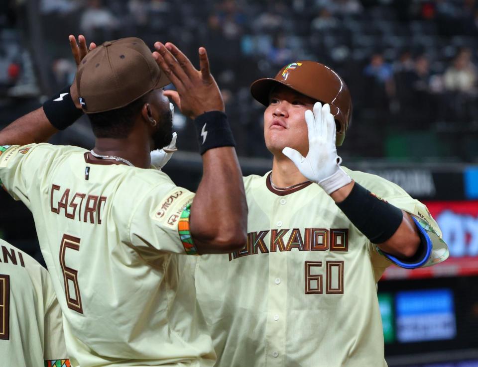 ５回、左越えに勝ち越しソロを放ちナインに迎えられる吉田（撮影・金田祐二）