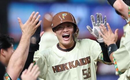 ９回、水野の適時三塁打で生還しナインに迎えられる奈良間（撮影・金田祐二）