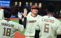６回、同点ソロを放ちナインに迎えられる吉田（撮影・金田祐二）