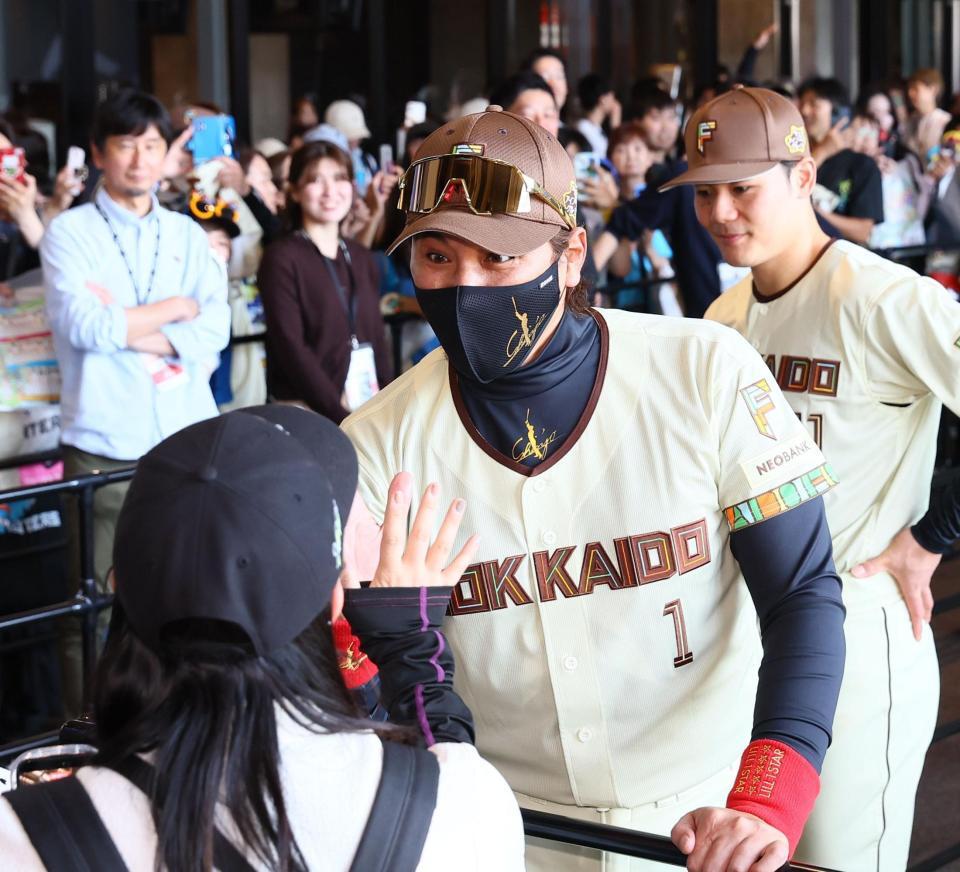 ウェルカムハイタッチでファンを迎える新庄監督（撮影・中島達哉）