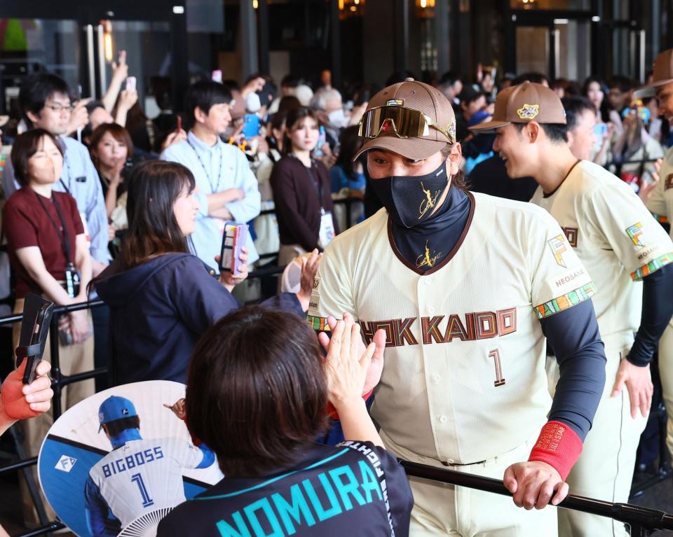 ウェルカムハイタッチでファンを迎える新庄監督（撮影・中島達哉）