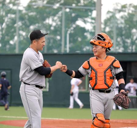 ５回を投げ終え、山瀬（右）とタッチを交わす田中将（撮影・西岡正）