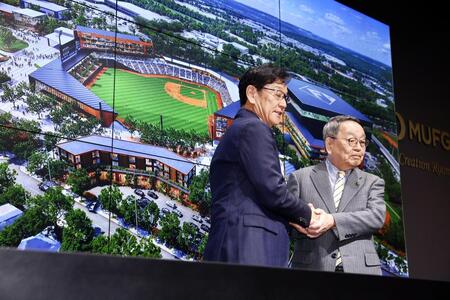 ２軍本拠地移転先に内定した原田裕恵庭市長（右）と握手し、記念撮影する栗山ＣＢＯ（撮影・中島達哉）