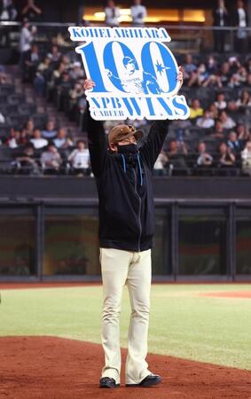 ＮＰＢ通算１００勝を達成した有原の記念ボードを掲げる新庄監督（撮影・中島達哉）
