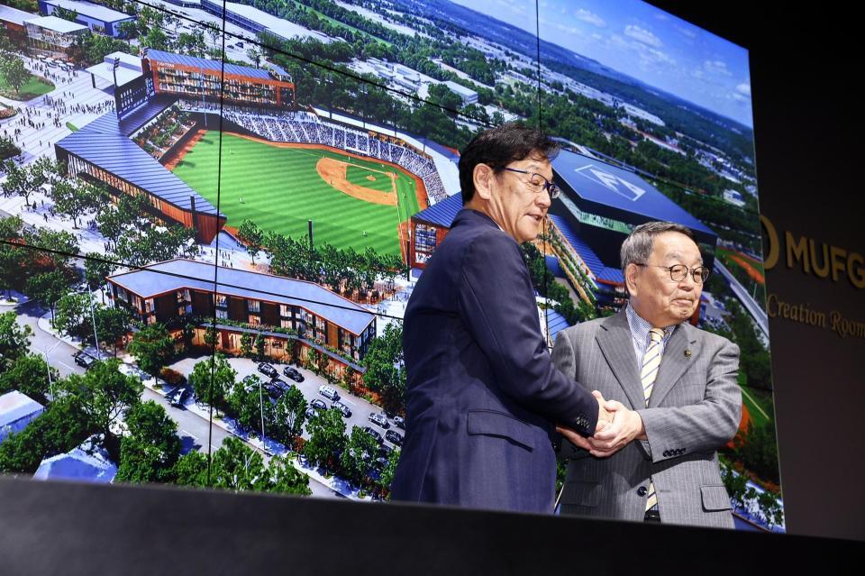 ２軍本拠地移転先に内定した原田裕恵庭市長（右）と握手し、記念撮影する栗山ＣＢＯ（撮影・中島達哉）