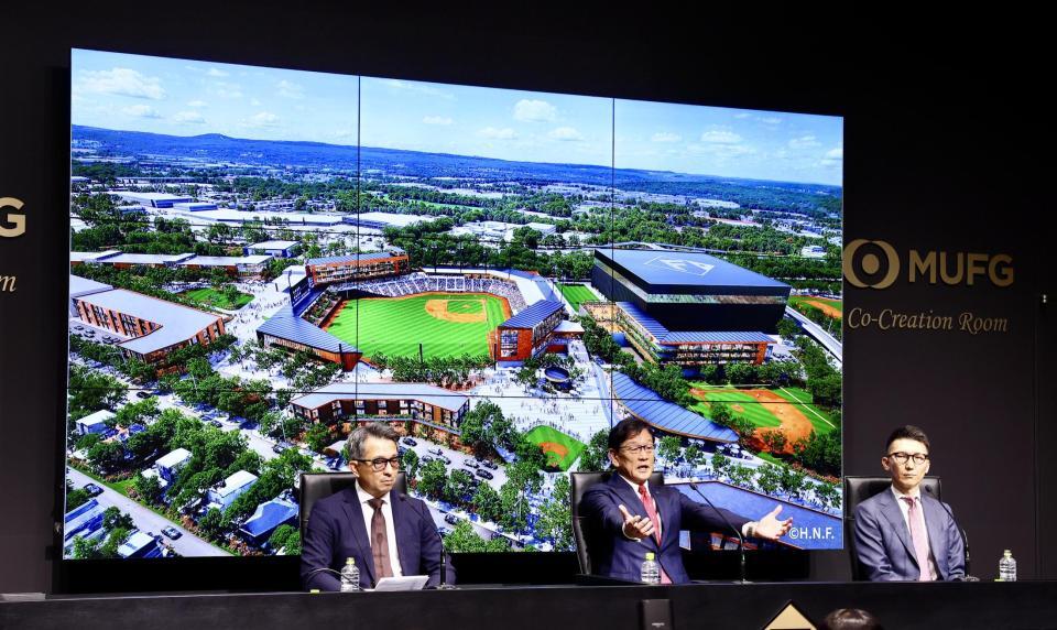 会見後、イメージを背に報道陣の取材を受ける（左から）株式会社ファイターズ　スポーツ＆エンターテイメント・前沢賢代表取締役社長、栗山ＣＢＯ、小林コーポレート本部副本部長（撮影・中島達哉）