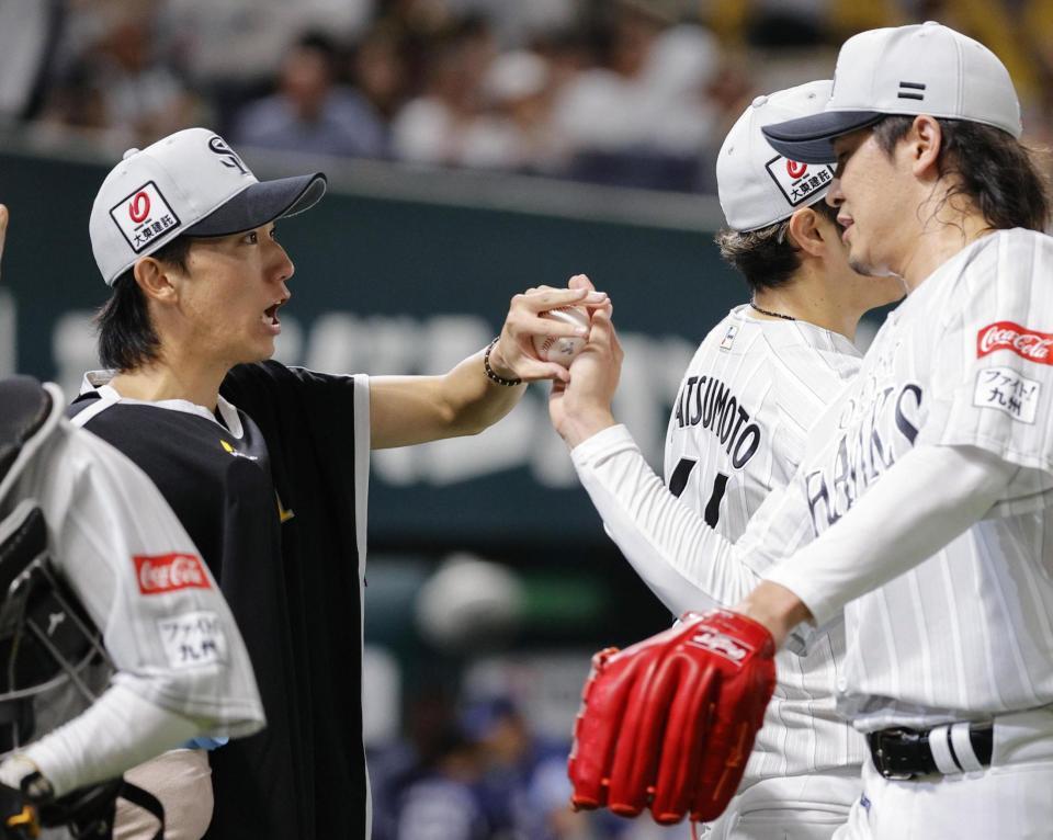 　７回１失点で８勝目を挙げ、杉山（右）からウイニングボールを受け取る大津