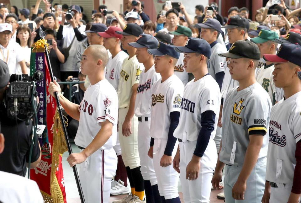 優勝旗を返還する広陵・曽根主将（左）＝撮影・北村雅宏