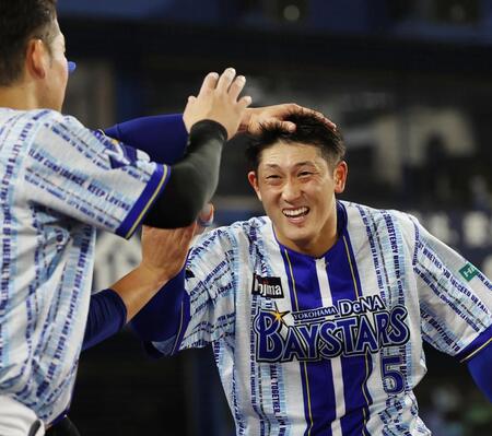 ６回、左中間ソロを放った松尾を迎えるナイン
