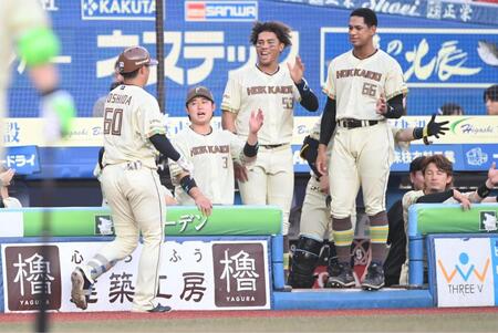 ２回、先制の右越えソロを放ちナインとタッチを交わす吉田（左手前）＝撮影・開出牧