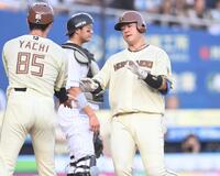 ２回、先制の右越えソロを放ち谷内コーチ（左）とタッチを交わす吉田。後方は捕手・佐藤（撮影・開出牧）