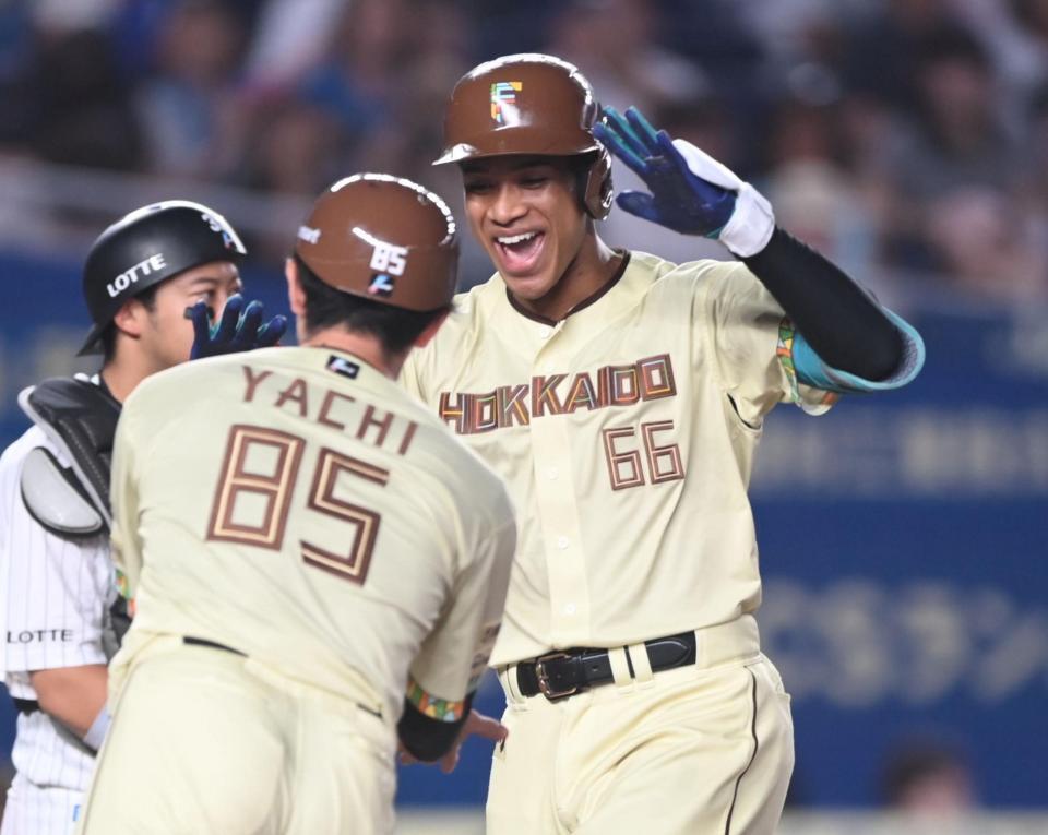 ７回、右越え３ランを放ち谷内コーチ（手前）とタッチを交わす万波（撮影・開出牧）