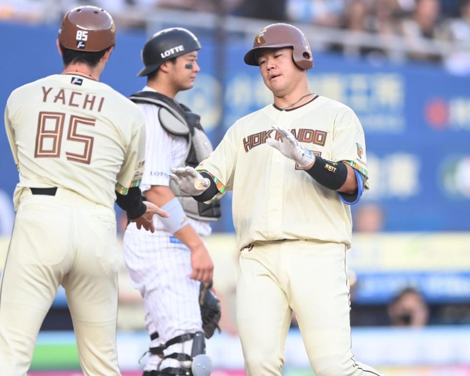 ２回、先制の右越えソロを放ち谷内コーチ（左）とタッチを交わす吉田。後方は捕手・佐藤（撮影・開出牧）
