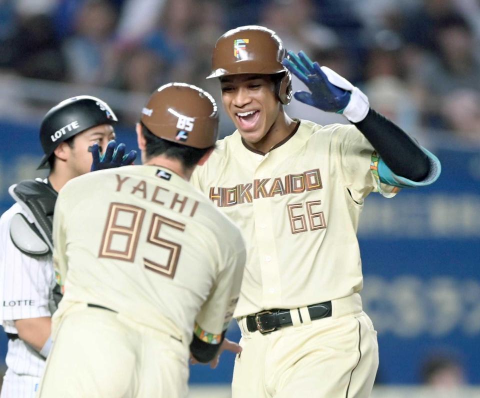　７回、右越え３ランを放ち谷内コーチ（手前）とタッチを交わす万波（撮影・開出牧）