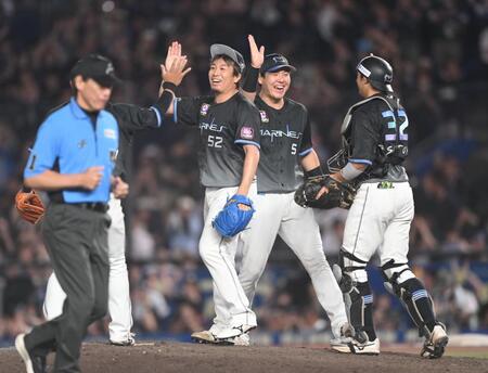 通算２４９セーブ目を挙げナインとタッチを交わす益田（５２）＝撮影・開出牧