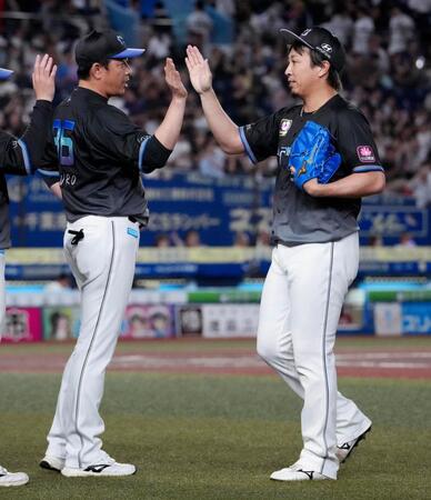 今季初セーブを挙げ、サブロー監督（左）とタッチを交わすロッテ・益田
