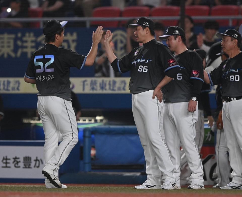 通算２４９勝目を挙げた益田（５２）とタッチを交わすサブロー監督（撮影・開出牧）