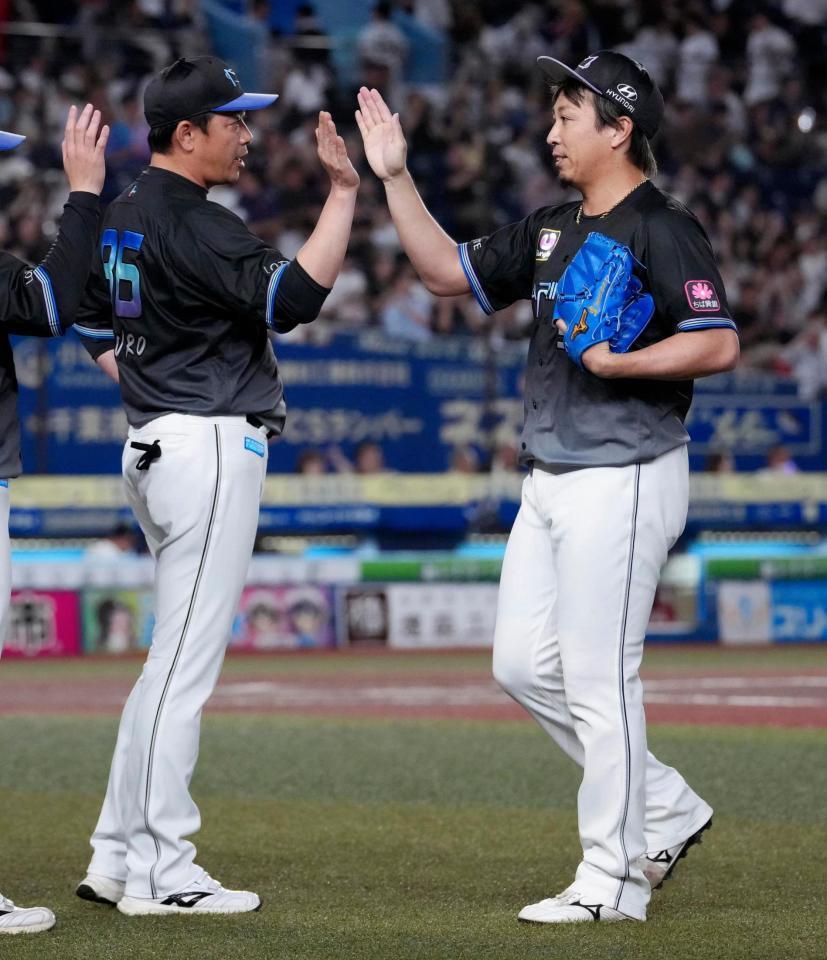 今季初セーブを挙げ、サブロー監督（左）とタッチを交わすロッテ・益田