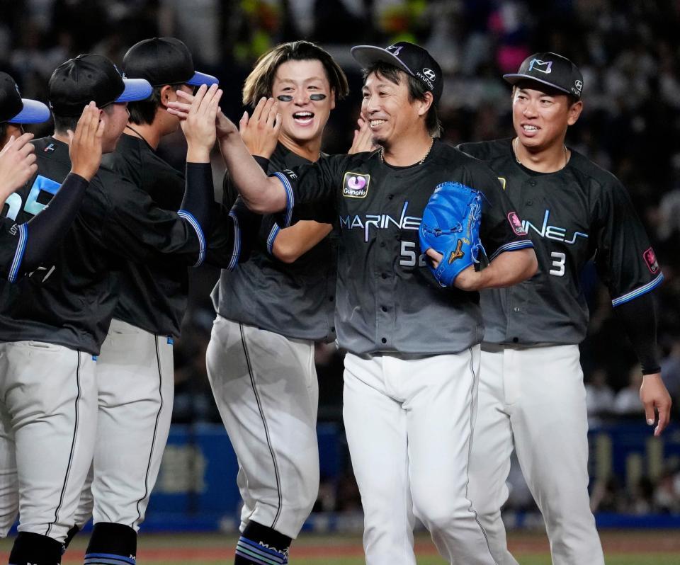 今季初セーブを挙げ、ナインに迎えられ笑顔のロッテ・益田（右から２人目）