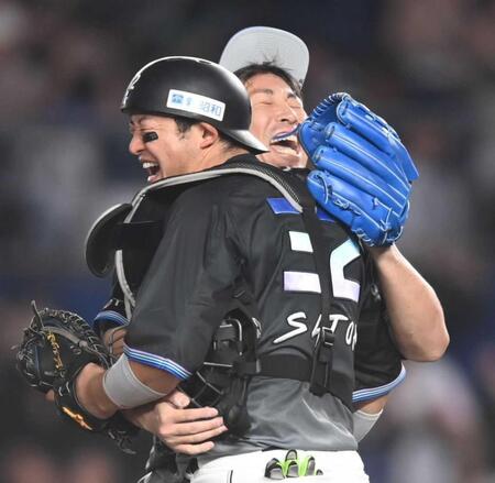 　９回を締めて佐藤（手前）と抱き合って喜ぶ益田（撮影・開出牧）