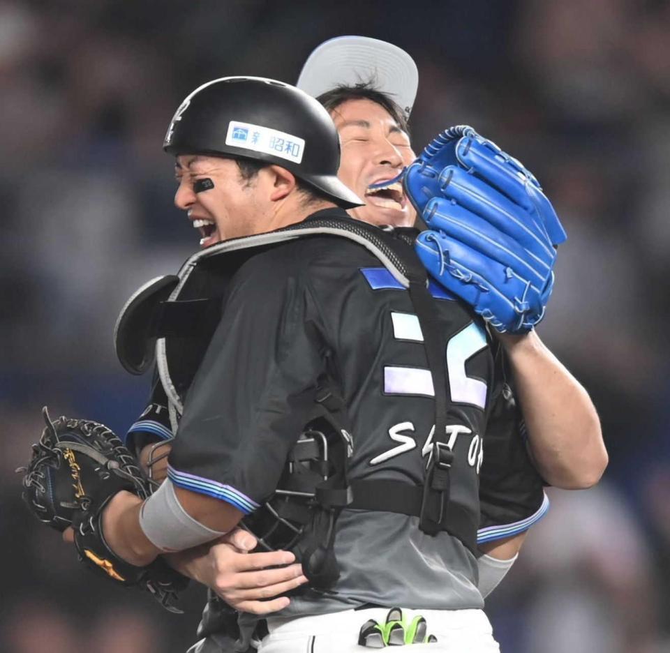　９回を締めて佐藤（手前）と抱き合って喜ぶ益田（撮影・開出牧）