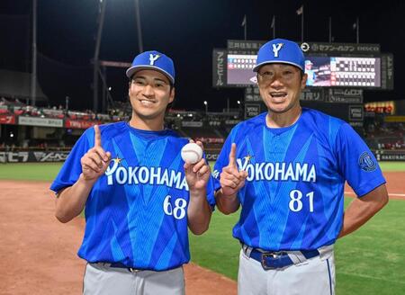 プロ初勝利を挙げ、相川監督（右）とポーズをとる岩田