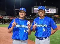プロ初勝利を挙げ、相川監督（右）とポーズをとる岩田