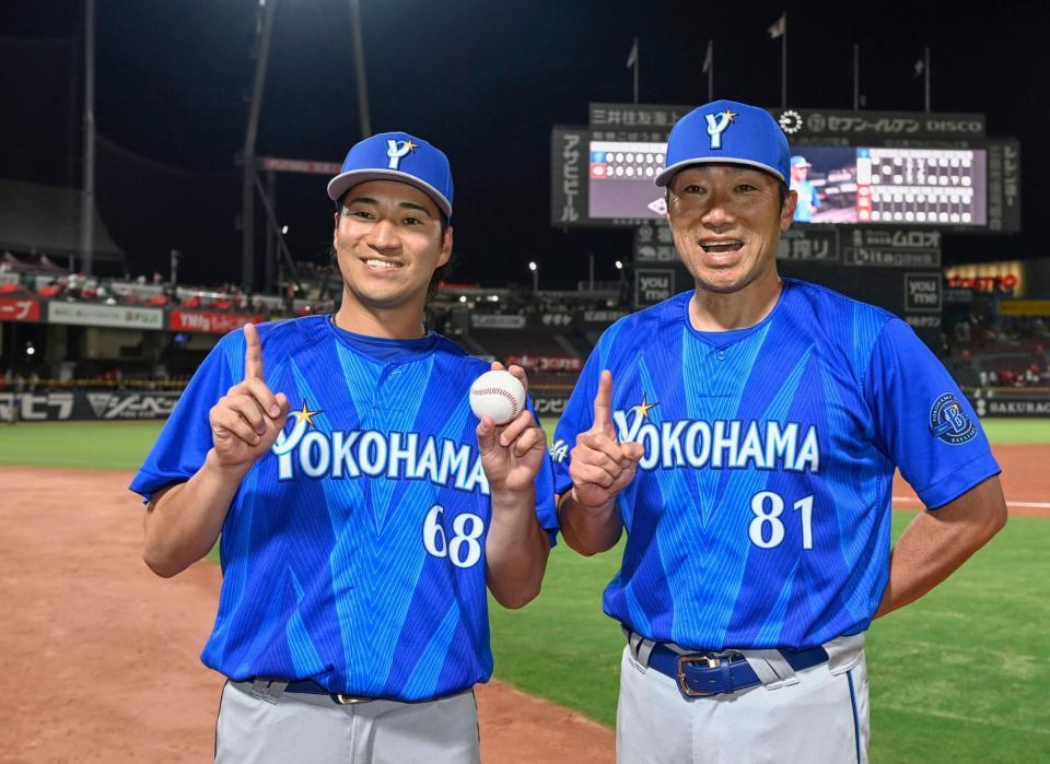 プロ初勝利を挙げ、相川監督（右）とポーズをとる岩田