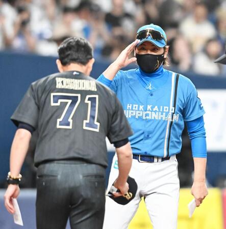 試合前、岸田監督（左）とメンバー表交換を行う新庄監督（撮影・高部洋祐）