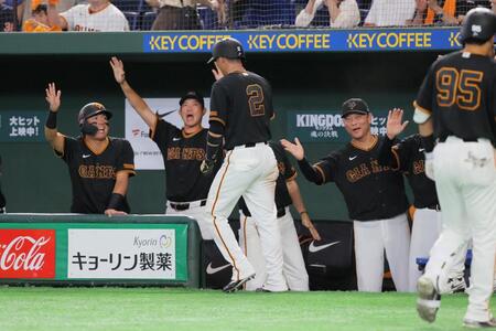 ５回、キャベッジの先制打で生還した吉川（中央）を迎える巨人の橋上監督代行（右）ら