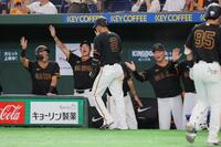 ５回、キャベッジの先制打で生還した吉川（中央）を迎える巨人の橋上監督代行（右）ら