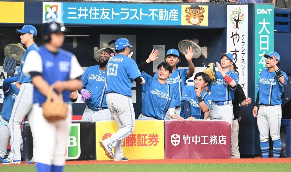 ３回、水野の２点二塁打で生還した吉田（６０）を迎える日本ハムナイン（撮影・高部洋祐）