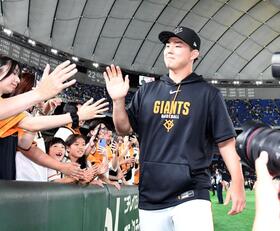 ファンとタッチを交わす小笠原（撮影・佐藤厚）