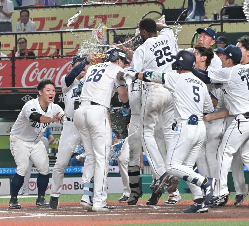 １０回、サヨナラホームランを放ちホームで手荒い祝福を受けるネビン（撮影・持木克友）