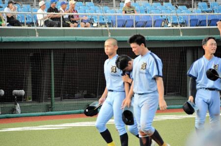 試合終了後あいさつを終えてベンチに戻る高岡第一・前田