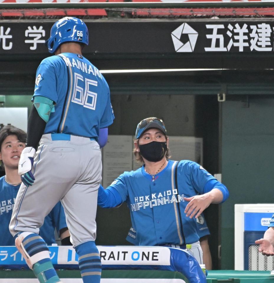 ６回、２点本塁打を放った万波（左）を迎える新庄監督（撮影・持木克友）