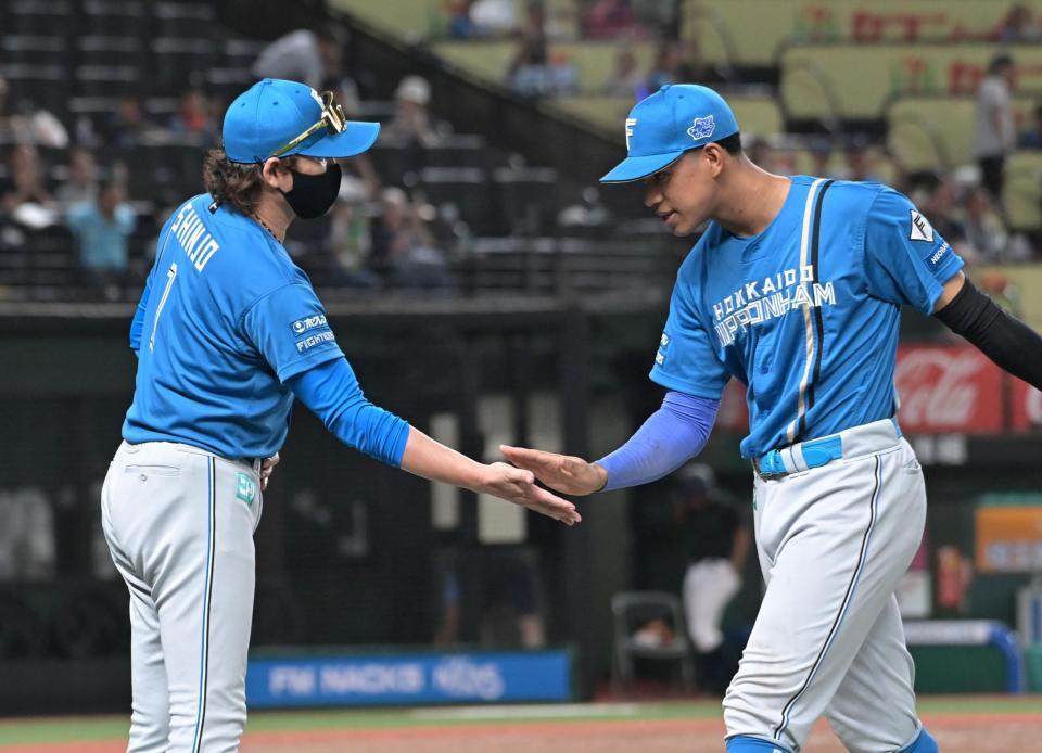 通算１００号本塁打を打った万波（右）を迎える新庄監督（撮影・持木克友）