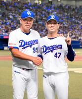 プロ初勝利を挙げ、井上監督（左）と写真に納まる中日・吉田