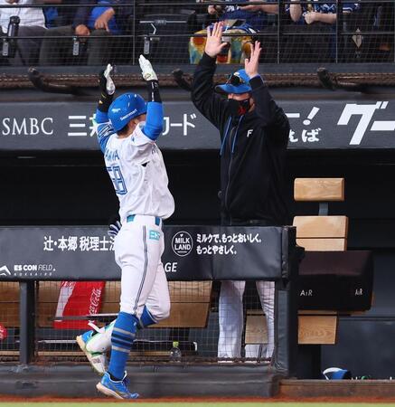 ７回、同点犠飛を放った奈良間（左）をハイタッチで迎える新庄監督（撮影・中島達哉）