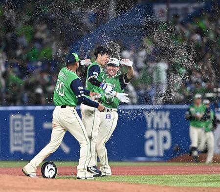 １０回、サヨナラの右犠飛を放ちナインから手洗い祝福を受ける古賀（中央）＝撮影・開出牧