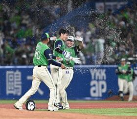 １０回、サヨナラの右犠飛を放ちナインから手洗い祝福を受ける古賀（中央）＝撮影・開出牧