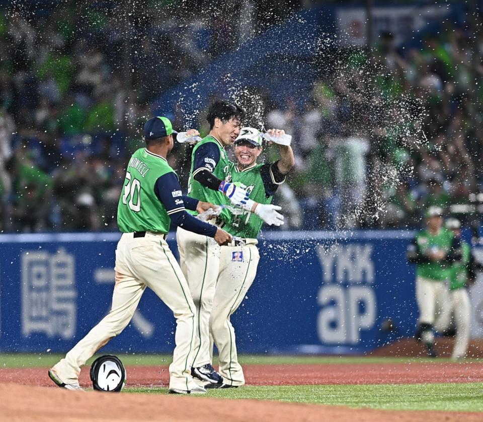 １０回、サヨナラの右犠飛を放ちナインから手洗い祝福を受ける古賀（中央）＝撮影・開出牧