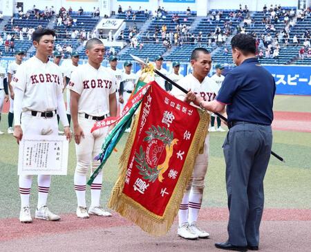 　優勝旗を受け取る拓大紅陵・加治主将（撮影・石井美幸）