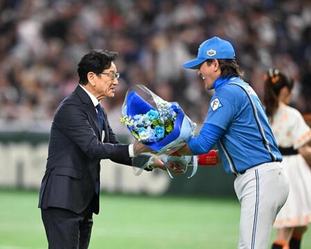 新庄監督（右）から花束を受け取る栗山英樹氏（撮影・堀内翔）