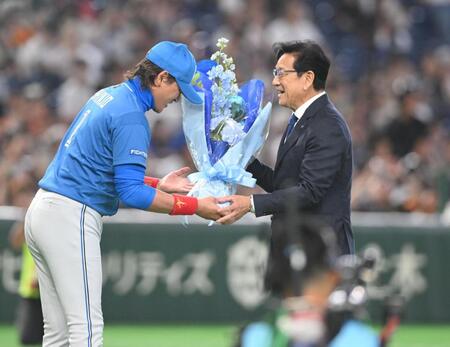 野球殿堂入り表彰式で新庄監督（左）から花束を受け取り感激の栗山英樹氏（撮影・開出牧）