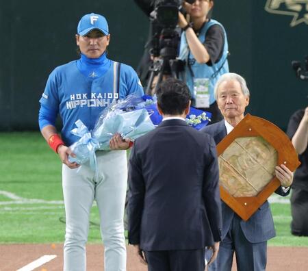 野球殿堂入り表彰式で栗山英樹氏に花束を贈呈する新庄監督（左）＝撮影・西岡正